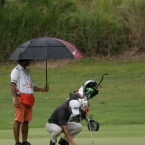 jay bayron covered with umbrella while setting his ball